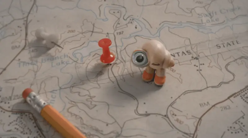 Marcel, La Concha Con Zapatos, Junto A Una Chincheta Roja Sobre Un Mapa Topográfico.