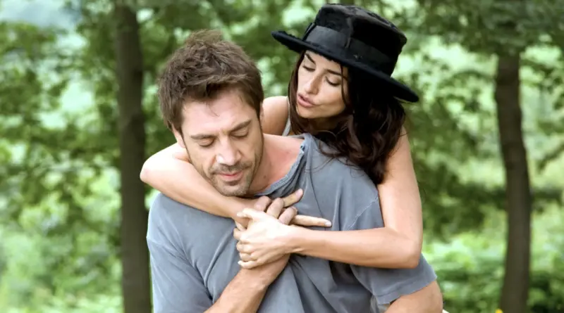 Penélope Cruz abrazando por la espalda a Javier Bardem en una escena de la película Vicky Cristina Barcelona en un entorno natural.