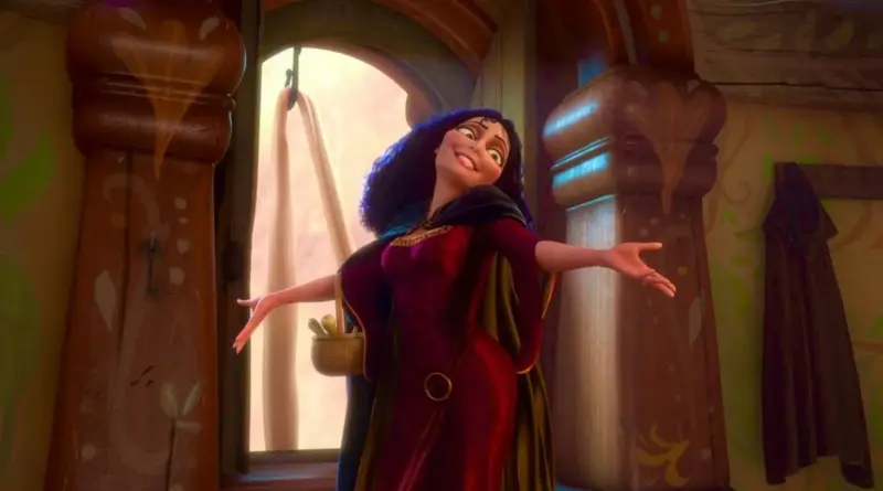 Madre Gothel, con su característico vestido carmesí y larga melena oscura y rizada, posa con los brazos abiertos y una sonrisa triunfante en el interior de la torre, con la ventana abierta al fondo mostrando el cabello de Rapunzel colgando.