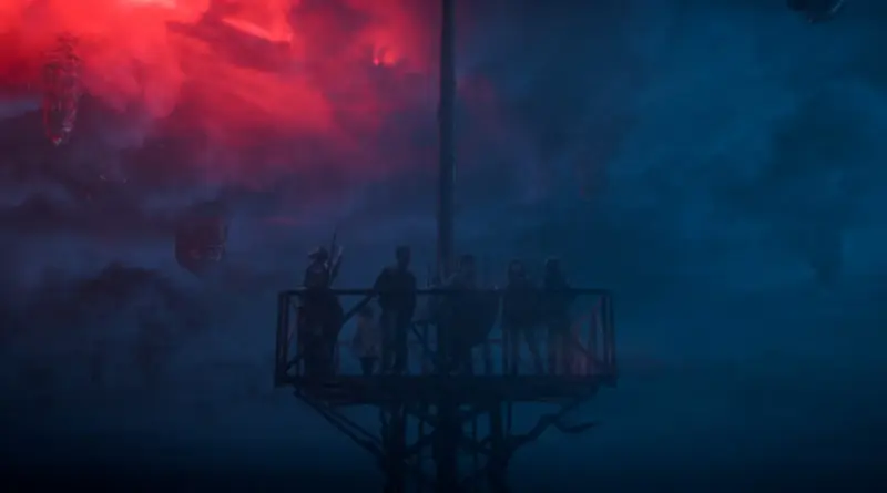 La banda sonora del episodio final de 'Stranger Things' y cómo consiguieron los derechos de 2 memorables canciones de Prince. 1 La pandilla de Hawkins sobre una estructura elevada observando el cielo dividido entre nubes rojas apocalípticas y la oscuridad del Mundo del Revés en el final de 'Stranger Things'.