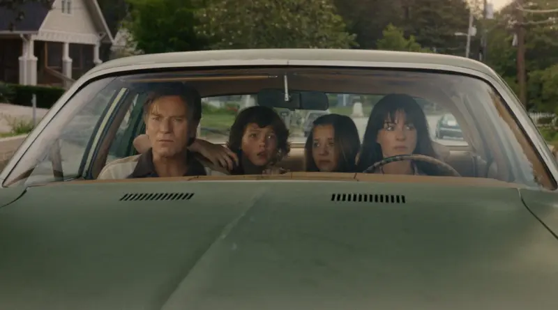 Fotograma De La Película 'El Final De Oak Street'.Anne Hathaway, Ewan Mcgregor Y Dos Menores Con Caras De Incredulidad Dentro De Un Coche Verde.