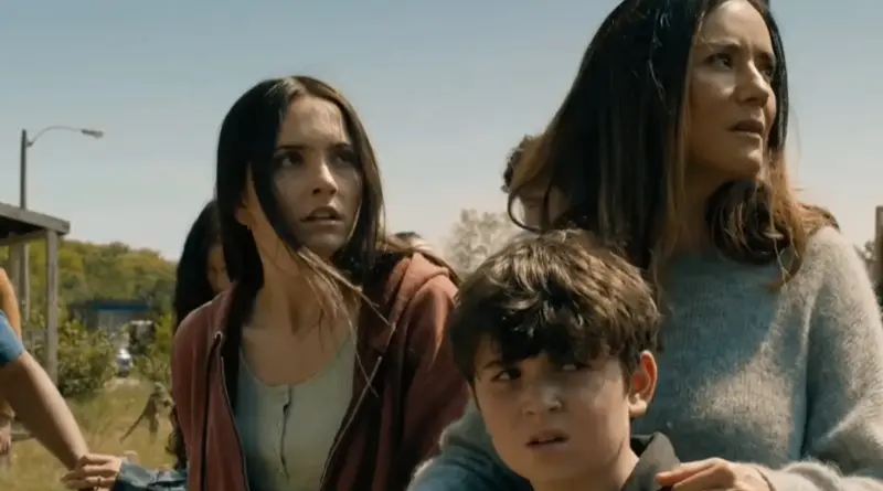 Fotograma De La Temporada 4 De 'From'. Tres Personajes De La Serie &Quot;From&Quot; (Una Joven, Un Niño Y Una Mujer) Mirando Hacia Un Lado Con Rostros De Preocupación En Un Entorno Al Aire Libre.