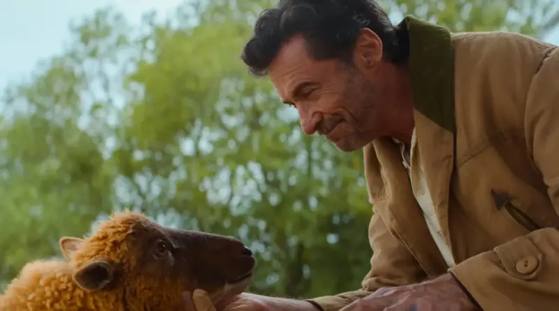 Fotograma De 'Las Ovejas Detectives'. Hugh Jackman Sonriendo Tiernamente A Una Oveja Marrón En El Campo.