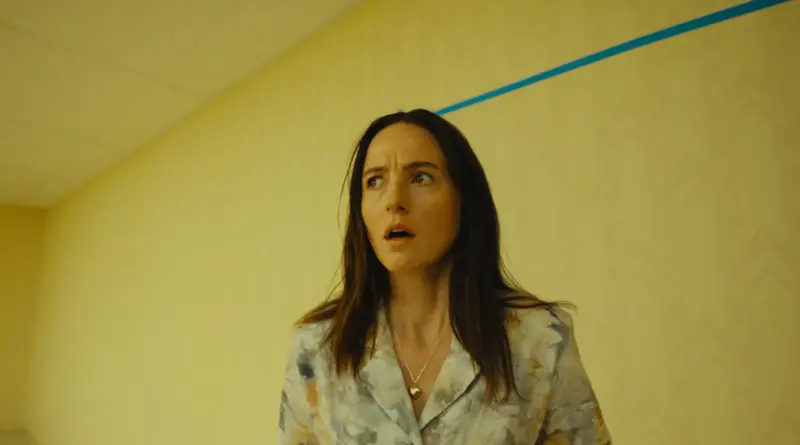 Actriz Renate Reinsve con expresión de confusión y miedo en una habitación de paredes amarillas con una línea azul en 'Backrooms'.