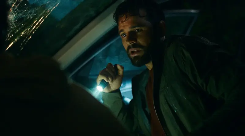 Personaje masculino usando una linterna dentro de un coche en la película El Pasajero Nocturno.