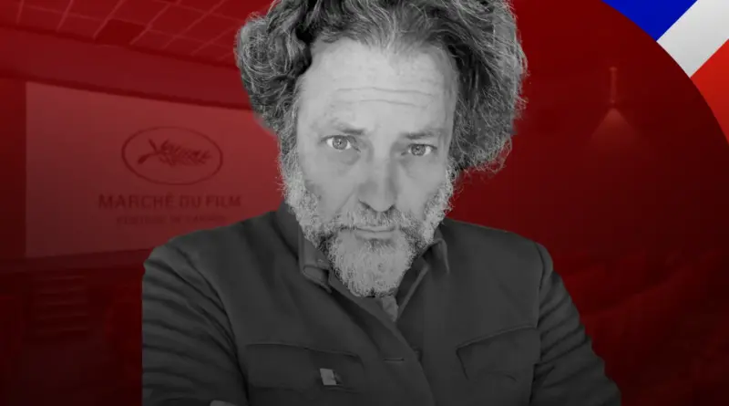 Primer plano en blanco y negro de Enrique López Lavigne frente al logo de Marché du Film del Festival de Cannes.