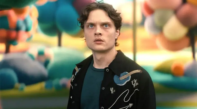 Primer plano del personaje Sam Riordan de Gen V. El fondo desenfocado con colores vibrantes y formas de marionetas representa sus alucinaciones recurrentes en la serie.