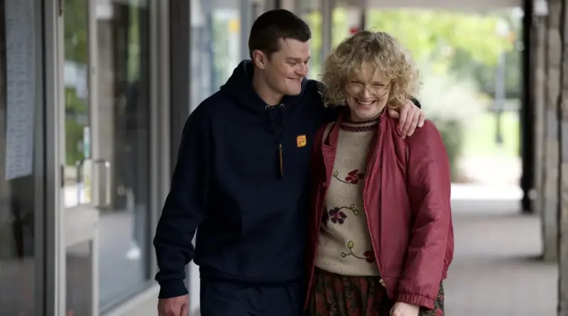 Robert Aramayo y Maxine Peake caminando sonrientes y abrazados en una escena de la película Incontrolable.