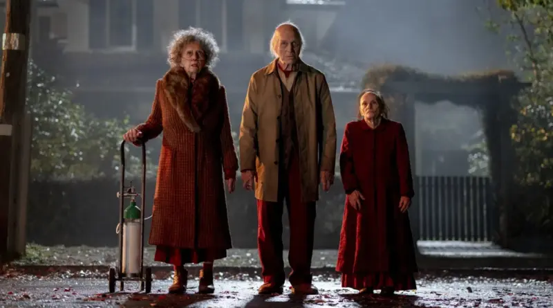 Entidades espectrales de Insidious: Fuera del más allá paradas en una calle neblinosa durante la noche.