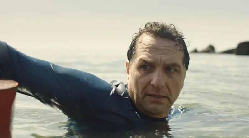 Matthew Rhys nadando en el mar en una escena de la serie La maldición de Widow's Bay.