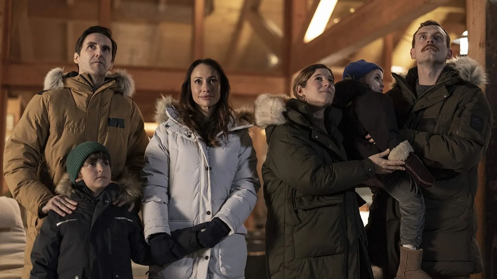 ¡Los estrenos destacados del mes de abril 2026 en España! 5 Reparto Principal De La Película Laponia, Todos Vestidos Con Ropa De Invierno En Un Interior Acogedor.