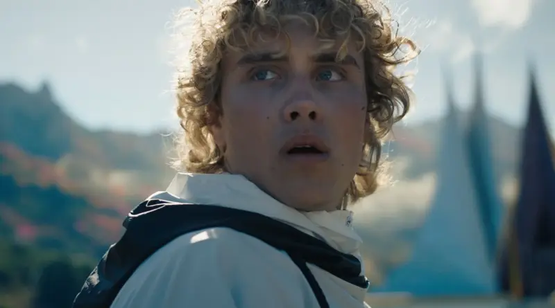 Joven Haymitch con cabello rizado mirando hacia atrás con preocupación en Los Juegos del Hambre: Amanecer en la Cosecha.