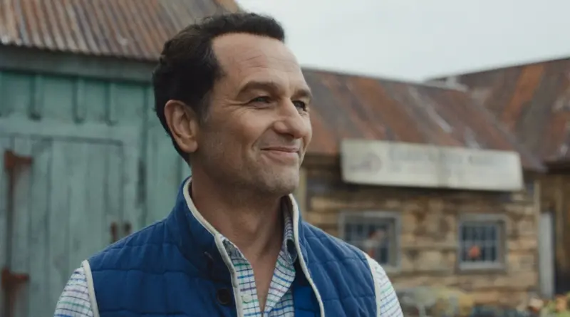 Matthew Rhys sonriendo en una escena de la serie Widow's Bay de Apple TV.