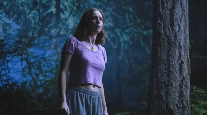 Fotograma de Teenage Sex and Death at Camp Miasma mostrando a una joven preocupada en un bosque oscuro de noche.