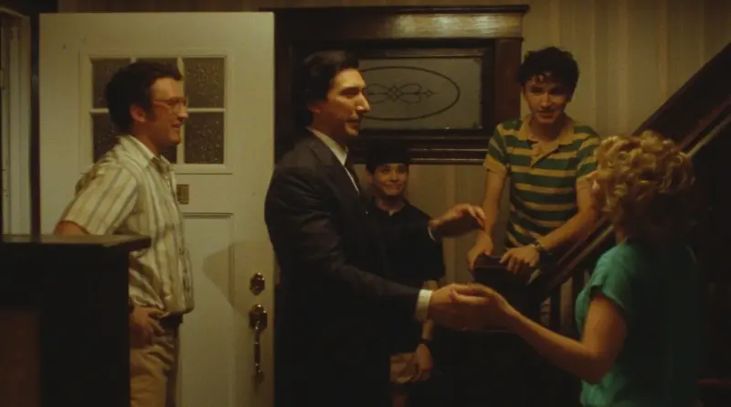 Fotograma de la película Paper Tiger (2026) dirigida por James Gray. Un hombre con traje estrecha la mano de una mujer en el recibidor de una casa familiar antigua.