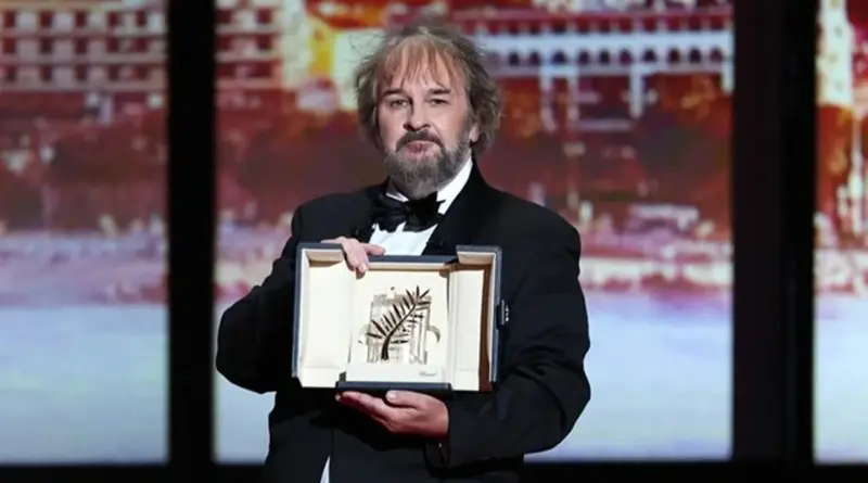 Peter Jackson sosteniendo el trofeo de la Palma de Oro de Honorífica en el escenario.