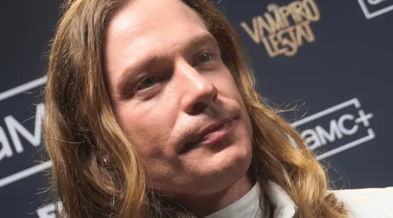 Primer plano del rostro de Sam Reid frente al cartel oficial de la serie The Vampire Lestat en Madrid.