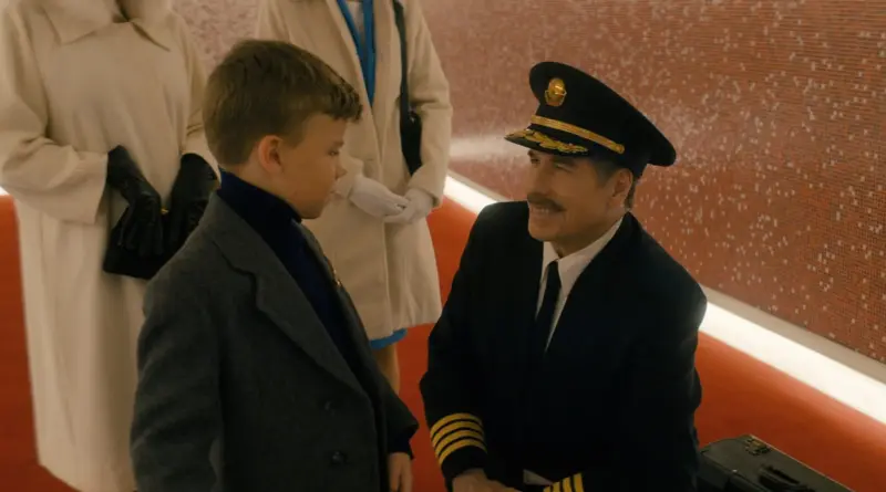 John Travolta caracterizado como piloto de época hablando con un niño, escena clave de 'Ven a volar conmigo' ('Propeller One-Way Night Coach').