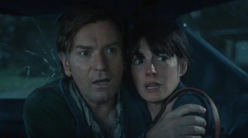 Anne Hathaway y Ewan McGregor con rostros de absoluto terror dentro de un vehículo en El final de Oak Street.