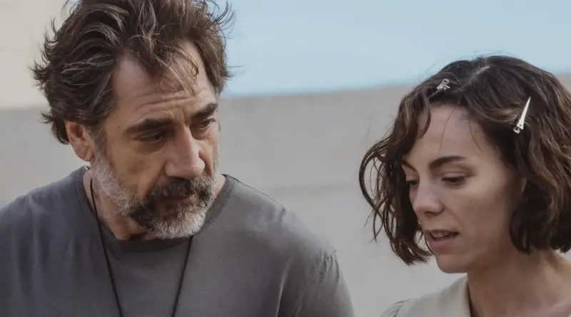 Javier Bardem y Victoria Luengo en un plano medio con expresión seria y pensativa en el exterior.