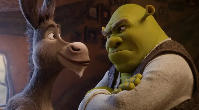Shrek 5: El burro Asno sonríe de perfil mientras mira alegremente a Shrek, quien responde con los brazos cruzados y una mirada de desconfianza.