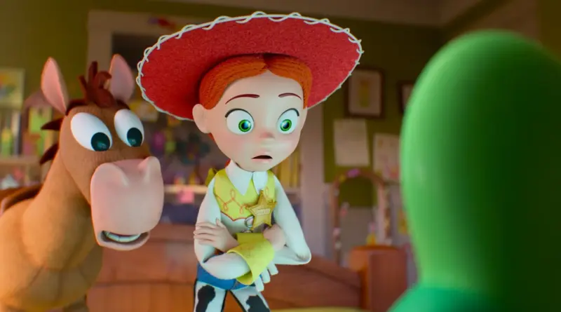 Toy Story 5: La vaquera Jessie con expresión de asombro y los brazos cruzados, junto al caballo Perdigón, mirando fijamente hacia una figura verde desenfocada en primer plano.