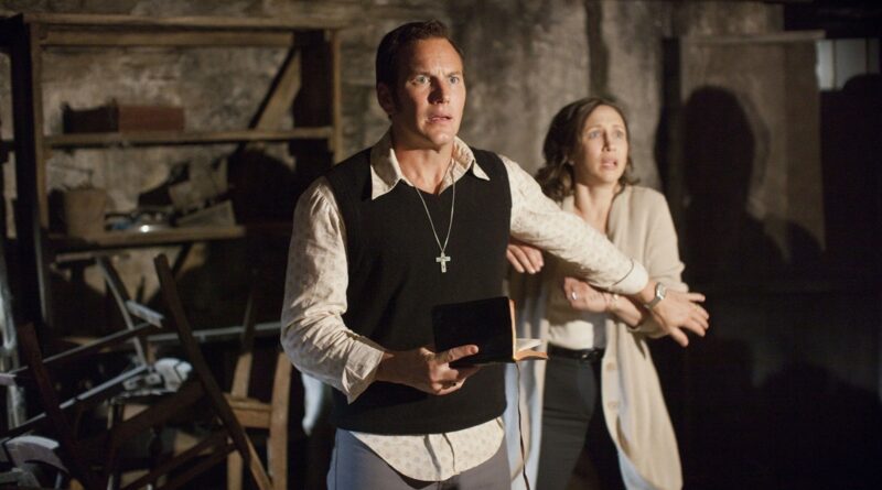 Patrick Wilson y Vera Farmiga como Ed y Lorraine Warren, asustados en un sótano oscuro. Ed sostiene una Biblia y lleva un crucifijo.