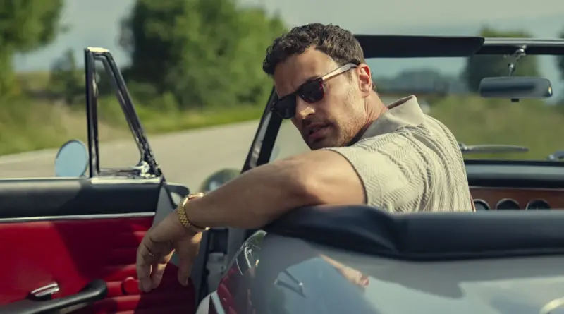 Theo James con gafas de sol mirando hacia atrás desde un coche descapotable en la temporada 2 de The Gentlemen.