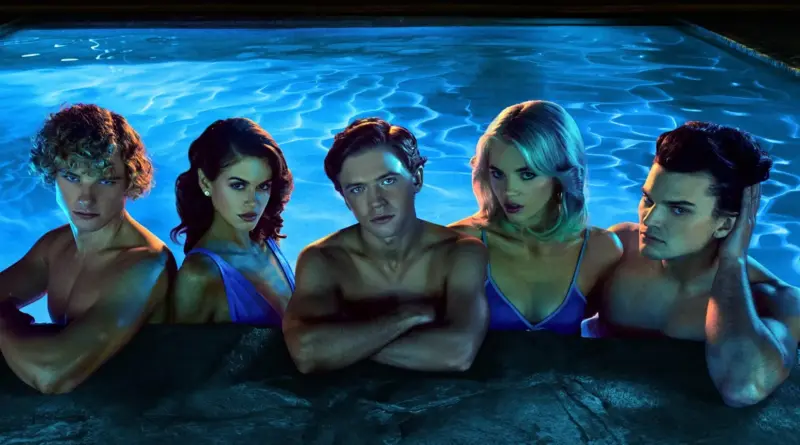 Cinco jóvenes del elenco de The Shards asomados al borde de una piscina con agua azul brillante por la noche.