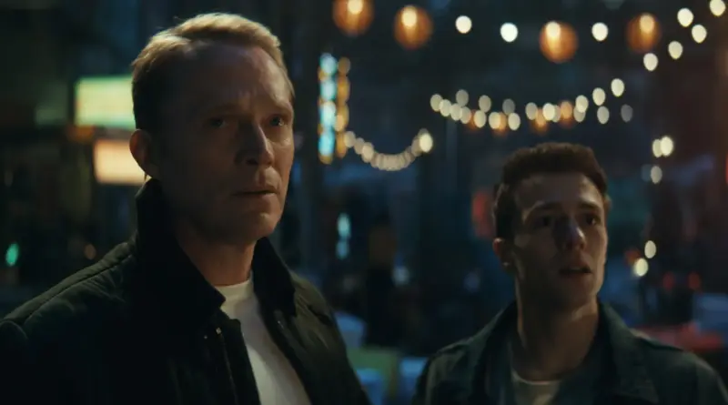 El póster promocional muestra a Paul Bettany como Visión en su forma humana, vistiendo un elegante traje gris a rayas y gafas. Está sentado en un sillón amarillo brillante, con las piernas cruzadas y leyendo con semblante serio un periódico titulado "VISION TODAY". Detrás de su sillón, de pie y con las manos apoyadas en el respaldo, se encuentra James Spader como un Ultrón con apariencia humana, que luce barba canosa, gafas y un abrigo oscuro. Sin embargo, el rostro y parte del cuerpo de este Ultrón humanoide están fragmentados, revelando su verdadera estructura robótica metálica debajo de la piel. El fondo es una clásica pared de madera con cuadros enmarcados. Toda la imagen está atravesada por un efecto visual de fallos digitales o "glitches" con líneas verticales de colores neón. En la parte inferior se lee el título "VISIONQUEST" y la fecha de estreno "14 de octubre" en Disney+.