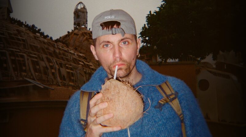 Primer plano de Raphaël Quenard bebiendo de un coco, con una estética fotográfica retro o de cámara desechable.