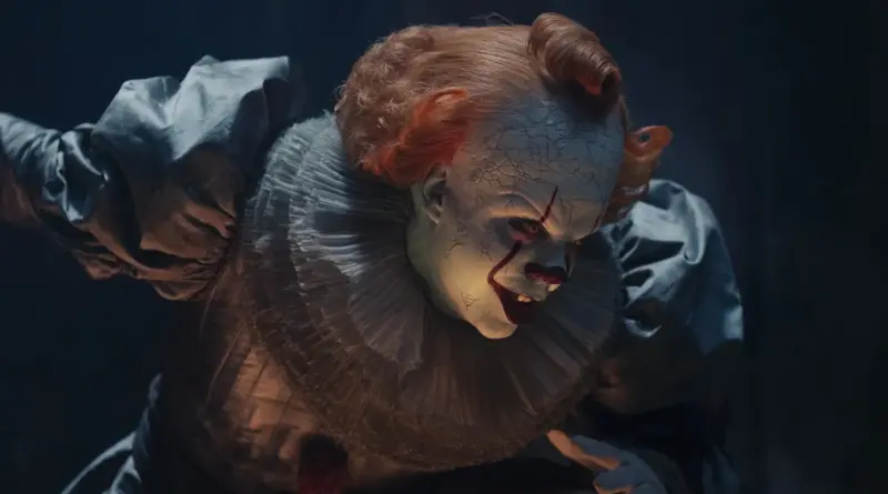 Primer plano del terrorífico payaso Pennywise acechando en la oscuridad en IT: Bienvenidos a Derry.