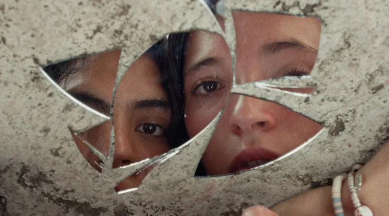 Los rostros fragmentados de las dos protagonistas de Chicas tristes reflejados a través de los pedazos de un espejo roto apoyado en el suelo.