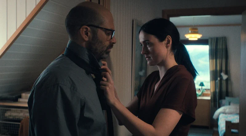 Texto alternativo (Alt text): Primer plano de un hombre y una mujer compartiendo un momento íntimo en la película Fjord, con ella ajustándole el cuello de la camisa.