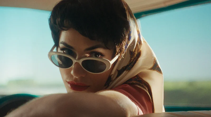 Primer plano de una mujer con gafas de sol y pañuelo en la cabeza en un fotograma de la película Glaxo.