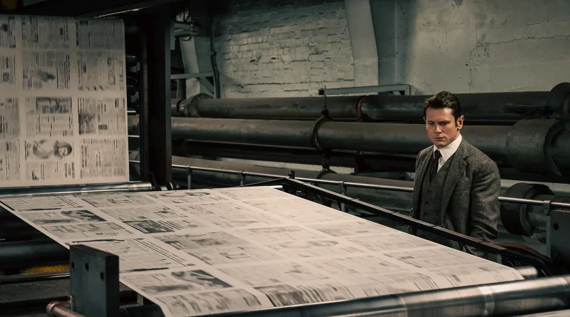 Jack O'Connell observa las enormes bobinas de papel impreso en la rotativa en la película Ink.