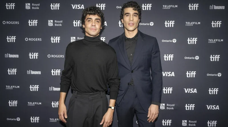 Los creadores de la película La bola negra posan juntos ante un panel promocional.