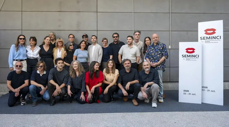 Fotografía de grupo de cineastas y actores posando sonrientes frente a los carteles oficiales de la 71 edición de la Seminci en 2026.
