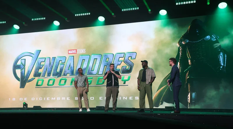 Los actores Anthony Mackie, David Harbour y Winston Duke en el escenario junto al presentador desvelando el logotipo y la fecha de Vengadores: Doomsday.