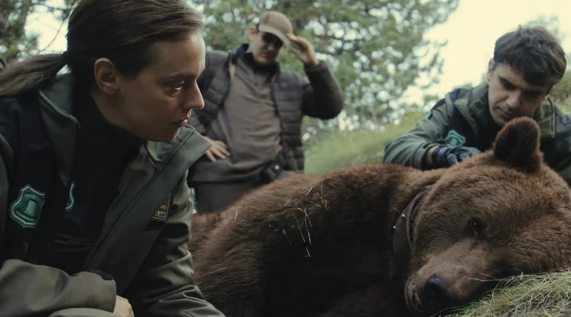 La actriz María Rodríguez Soto y el actor Pol López, caracterizados como agentes forestales, examinando el cuerpo de un oso en el suelo en Matar a un oso.