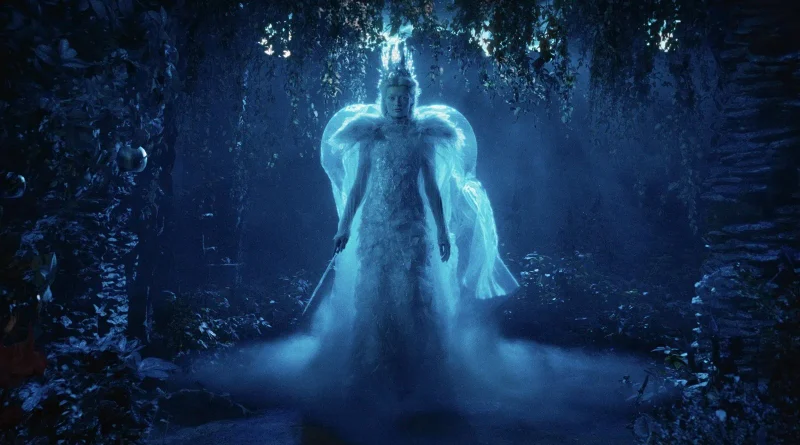 La Bruja Blanca brillando con una luz azul glacial en un bosque sombrío en Narnia: El sobrino del mago.