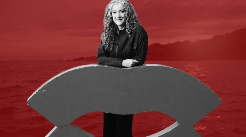 Retrato en blanco y negro de Sandra Sánchez apoyada sobre una estructura gris, con un paisaje marino de color rojo intenso de fondo.