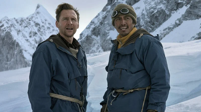 Tenzing y Edmund Hillary, equipados con pesada ropa de alpinismo azul, miran con asombro hacia la cima de un pico nevado.