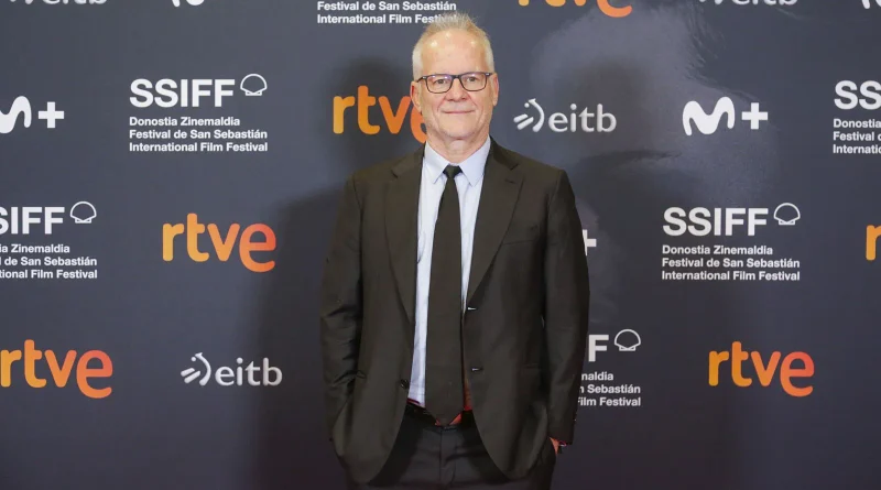 Thierry Frémaux posando sonriente con traje oscuro en el panel de prensa del Festival de San Sebastián.