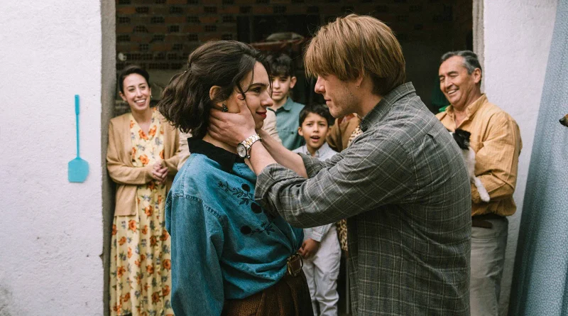 Patrick Criado acariciando el rostro de Claudia Traisac frente a familiares sonrientes en el patio de una casa en Una familia.